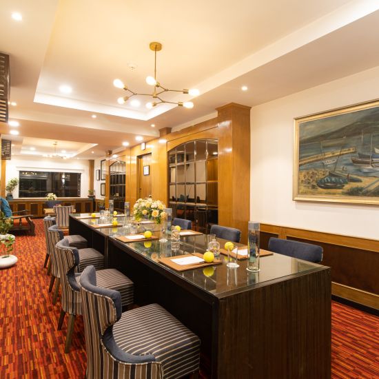 Captain's Cabin- Elegant bar lounge with red carpet, seating, and framed artwork in  Polo Floatel Kolkata