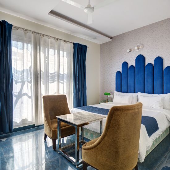 Blue themed Superior Deluxe Room with king size bed and chairs - The White Moon