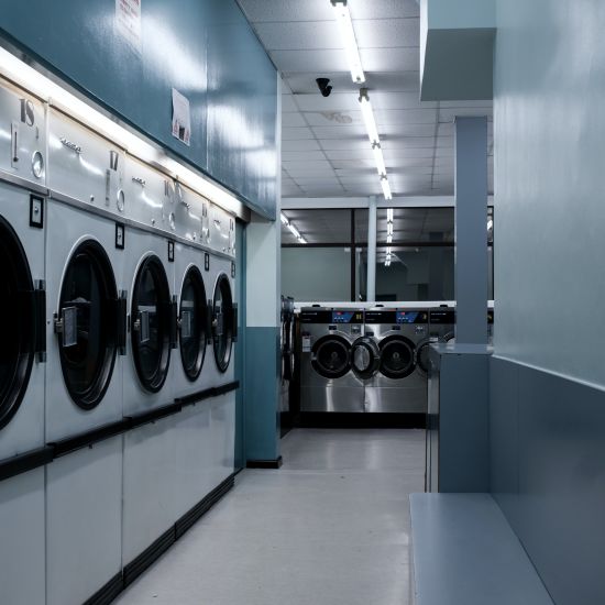 a room with bright lights and multiple washing machines for laundry