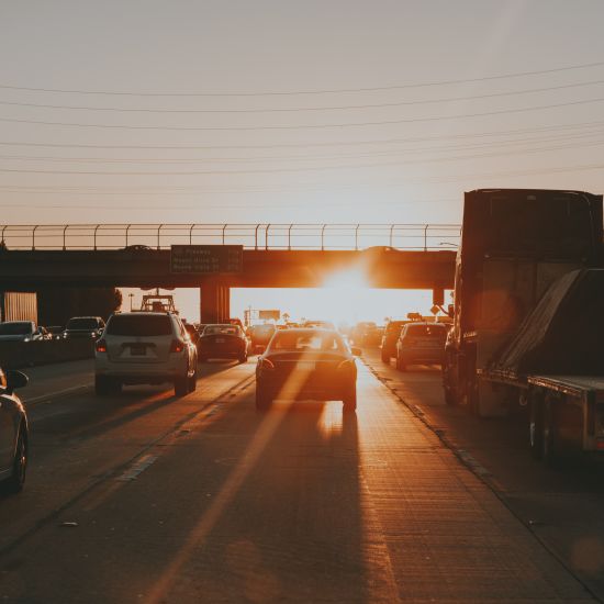 a few cars spotted during traffic captured during sunset