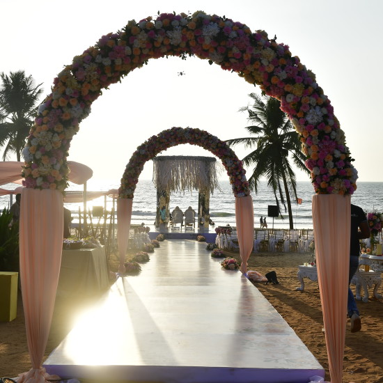 Archways leading to beach decorated with flowers for your destination wedding venue in goa