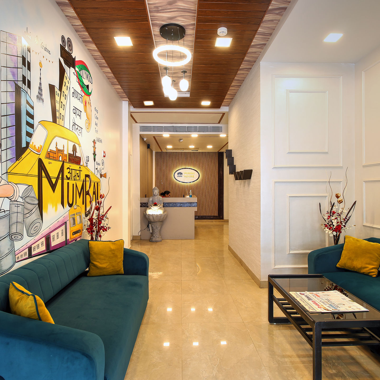 A vibrant lobby with a colorful mural wall representing Mumbai, plush sofas, and a front desk.