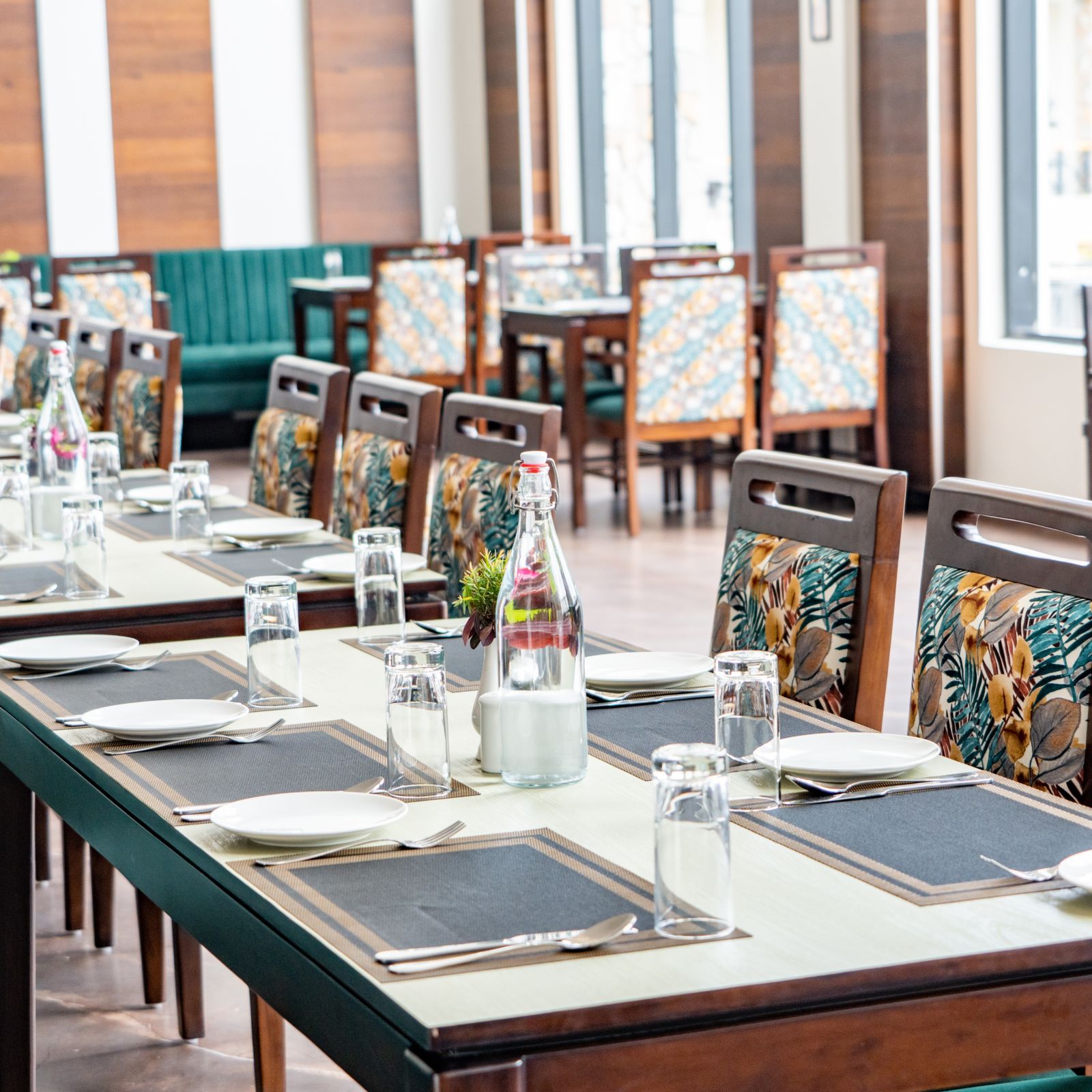 A close up shot of a long table with plates and cutlery in our restaurant - Shervani Pebbles & Pines, Corbett