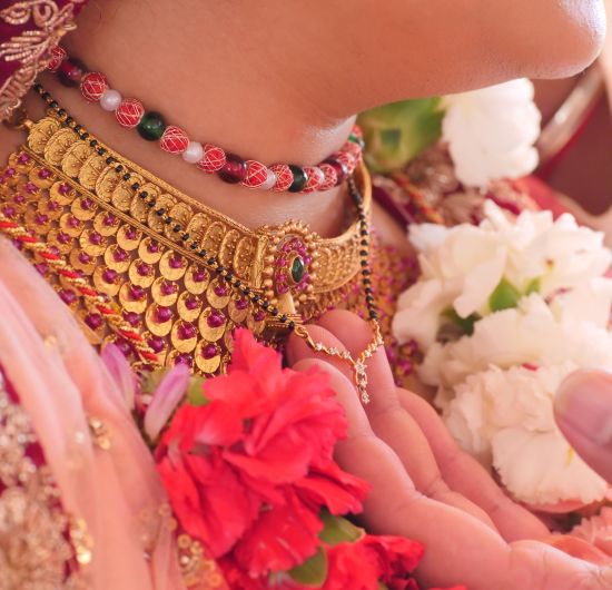 alt-text a woman wearing golden ornaments and pink saree