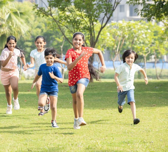 alt-text a group of children running on a grassy field during daytime