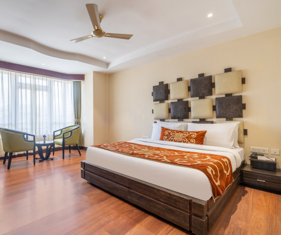 alt-text room with a king size bed and wooden interiors at summit lillium hotel and spa