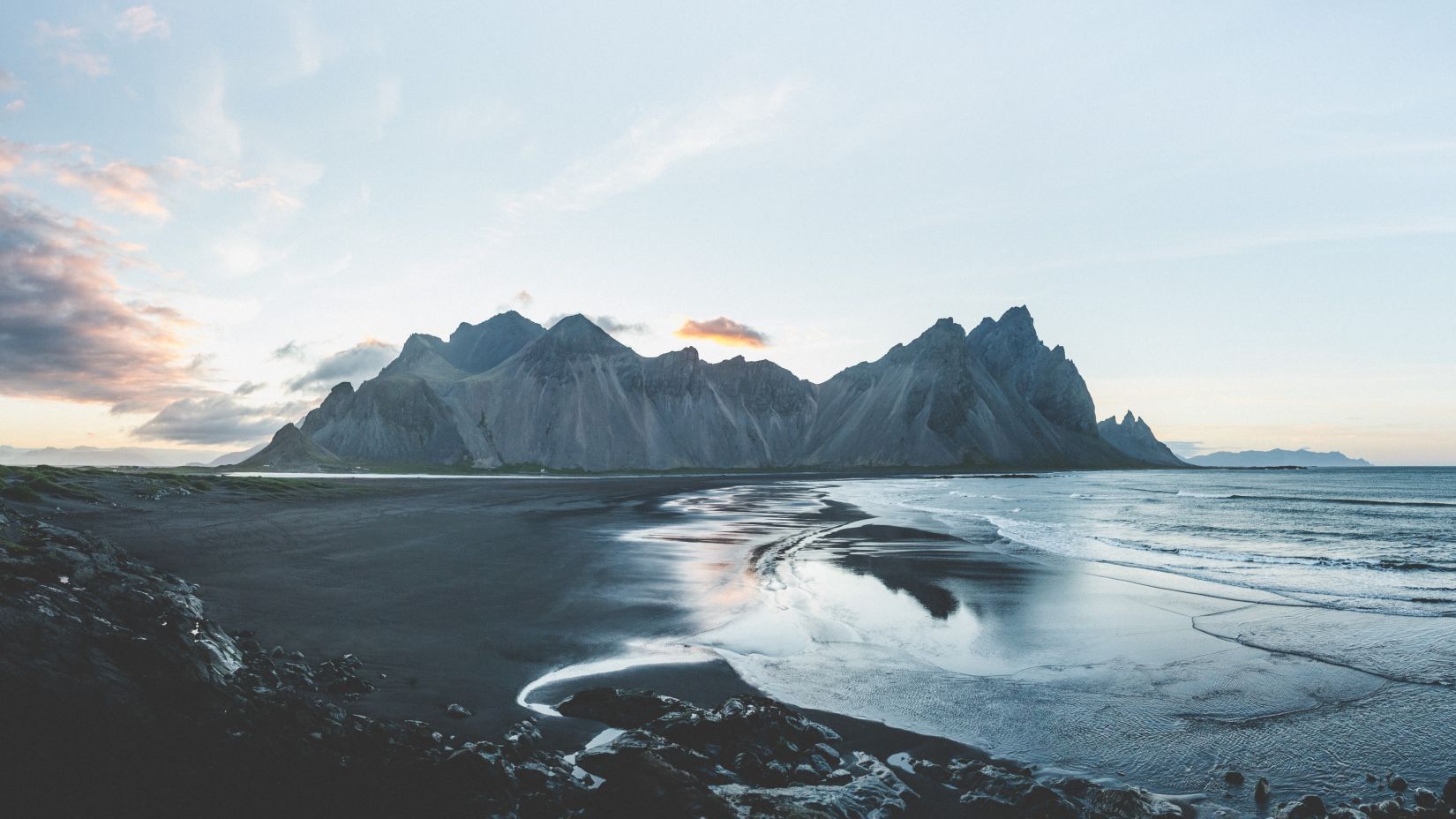 beach with black sand and high tides with hills in distance