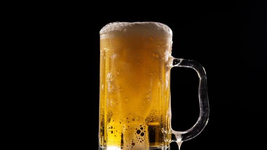 An image of a beer mug on a table with black background