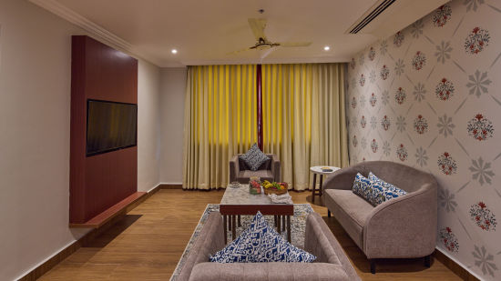 the living space decked with sofas and a table at the suite - Golden Tulip, Tirupati 