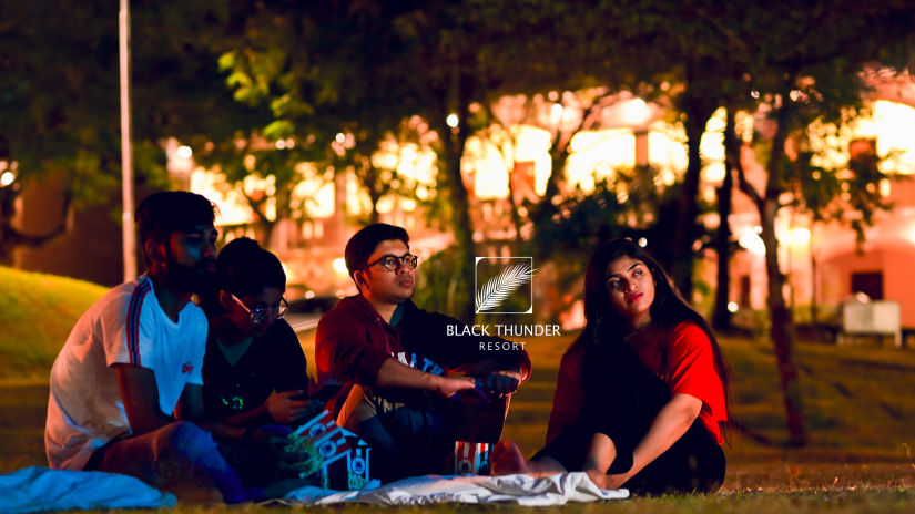 a group of people looking at something in the night - Black Thunder, Coimbatore