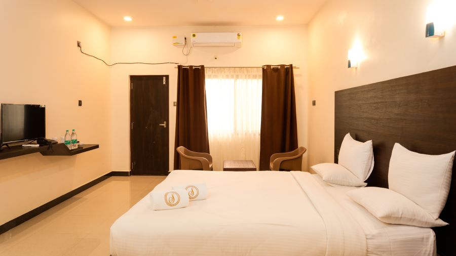 A double bed with a tv opposite it inside standard ac room - Mastiff Select Shreeyog Resort