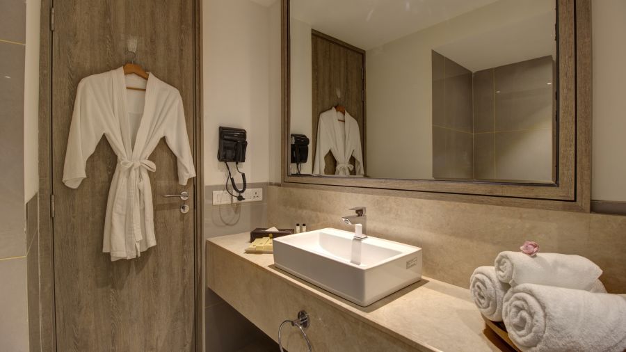 overview of the bathroom of Two bedroom Executive Suite with a bathrobe kept on a hanger