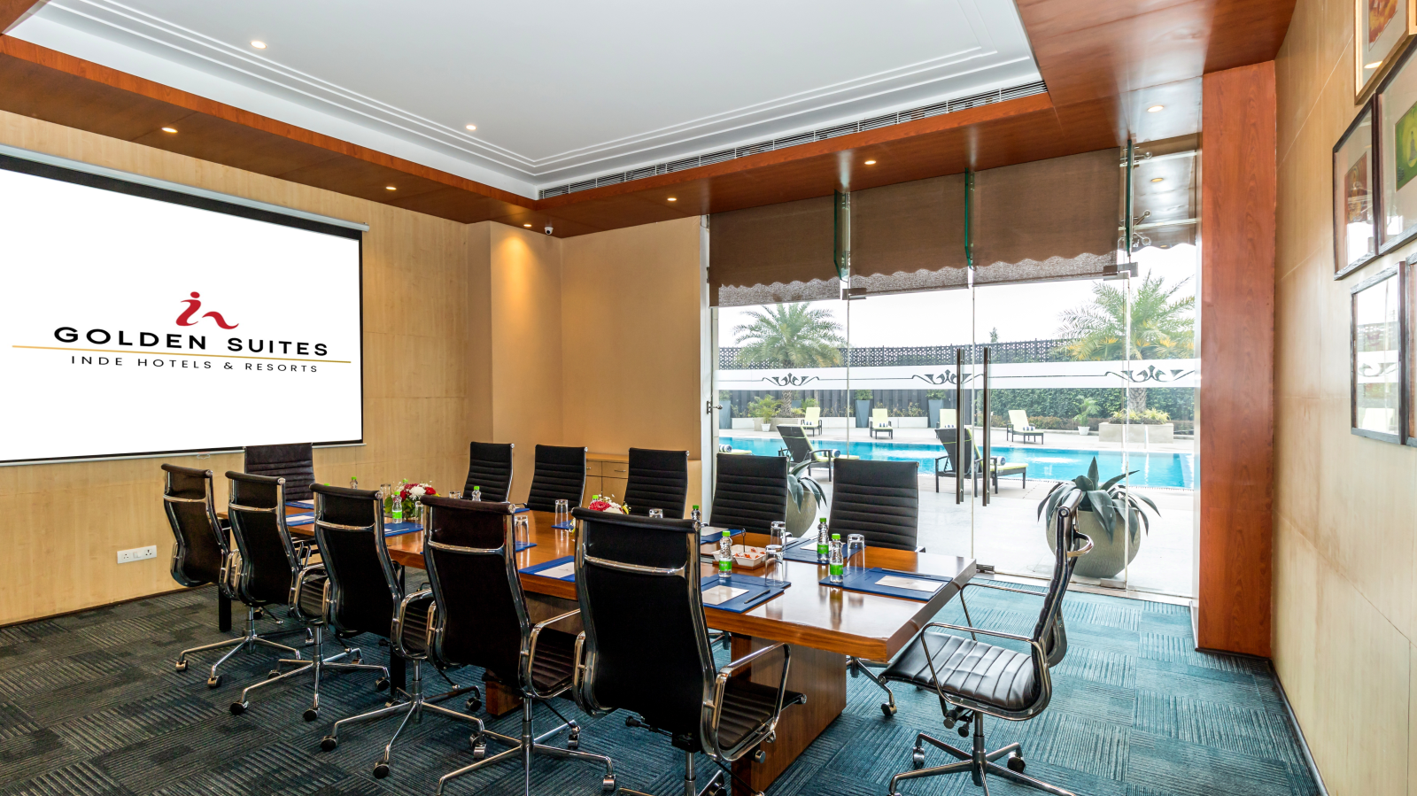 Boardroom with chairs round the table and a screen at Golden Suite