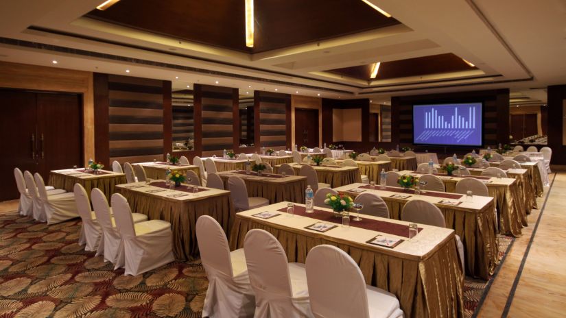 One of the banquet halls at Ananta spa & resort fully decked up with chairs, tables and a projector screen for events in pushkar 