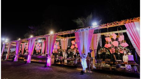 the outdoor venue prepped with decorated furniture adorned with pink curtains