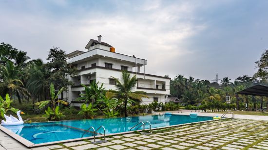 Overview of the swimming pool with Mastiff Select Shreeyog Resort in the background