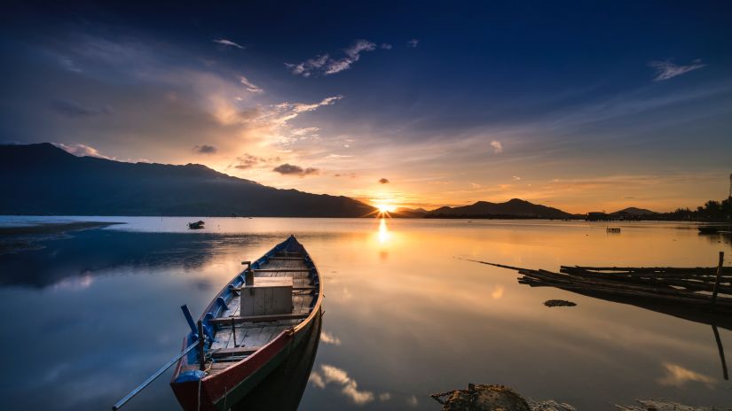 Boat in a lake with sunset backdrop