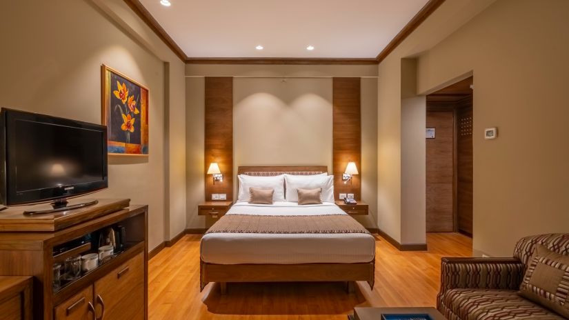 front view of a double bed with beige linen in the Business Club Room - Kenilworth Hotel, Kolkata