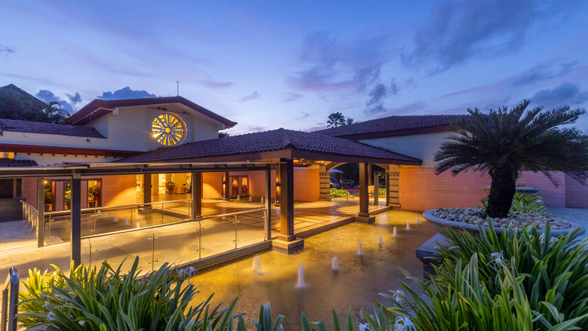 An overview of an empty hall in the evening with lights on and the evening sky in the background - kenilworth resort & spa, goa