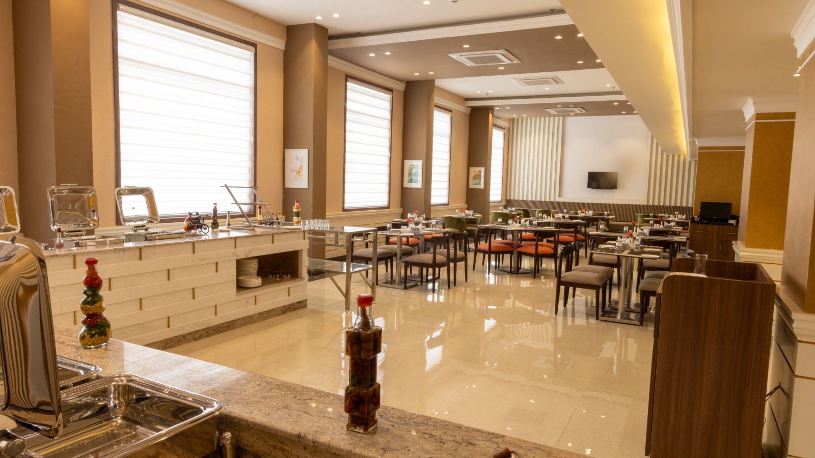 Seating arrangement inside the restaruant with the buffet in view - Starlit Suites, Tirupati