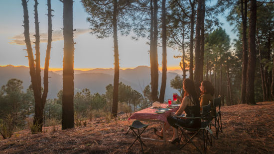 The Manor Shimla - Two women looking at the mountains with cutlery placed on the table in front of them