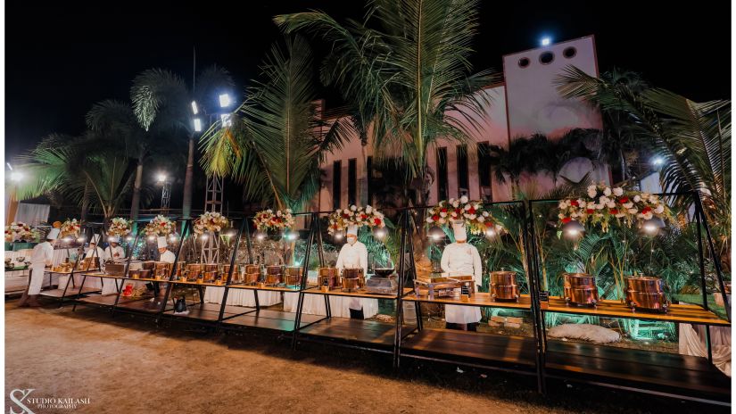 The servers stand behind the buffet, overseeing the spread during a special occasion.