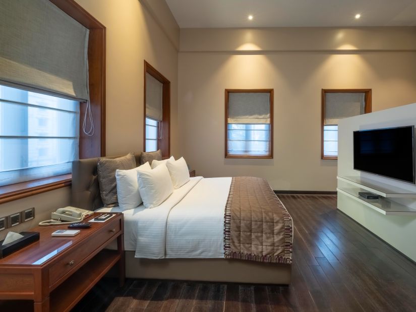 side view of the bed with a television in front at the Premier Club Room at Kenilworth Hotel, Kolkata