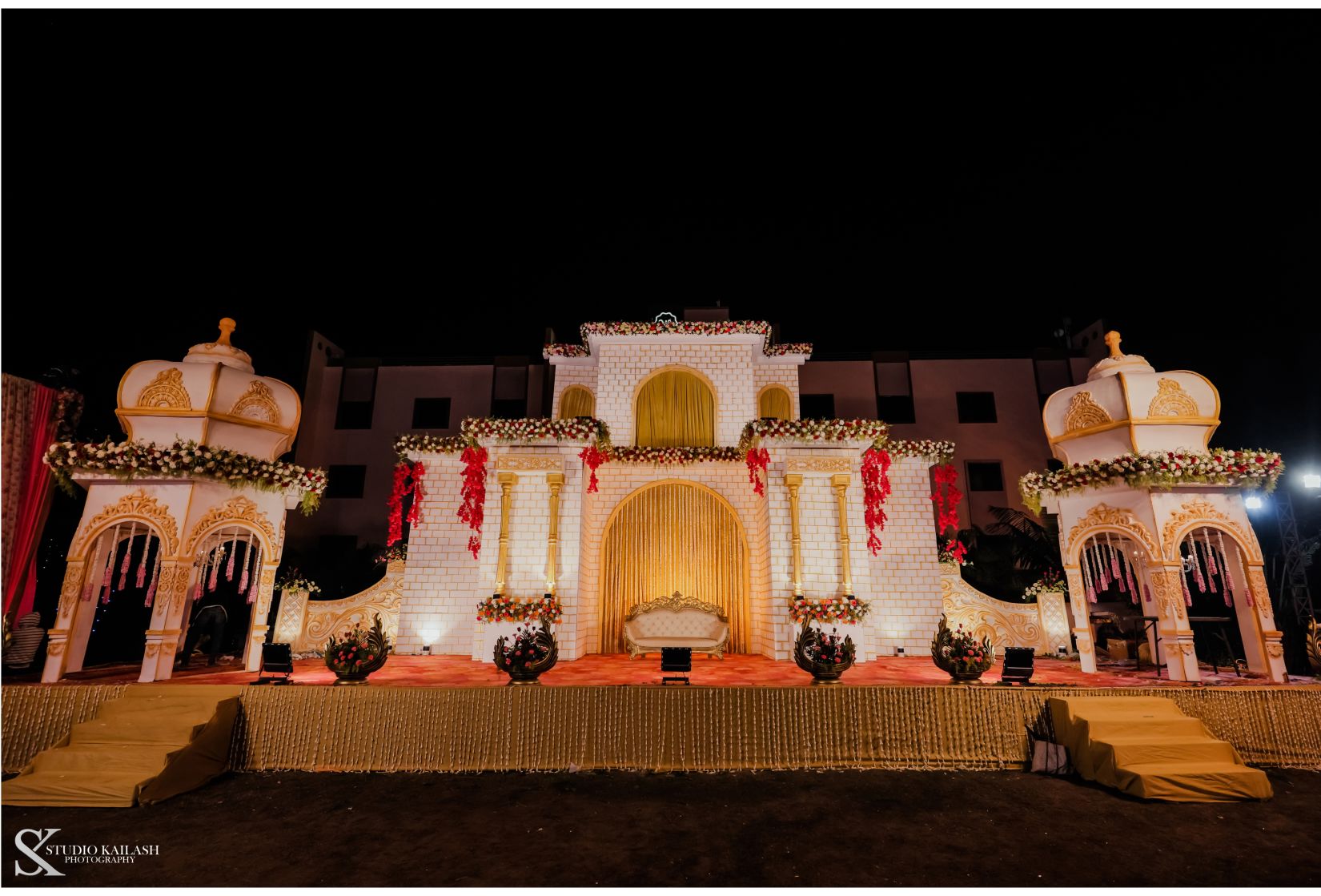 A podium adorned with castle-like structures stands against a backdrop, creating a regal setting for what appears to be a wedding.