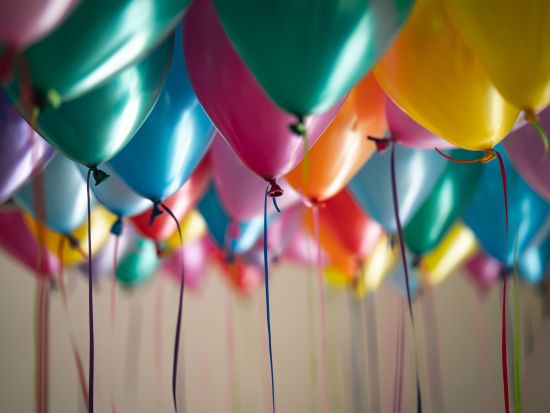 Numerous balloons filled with helium that are floating