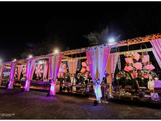 the outdoor venue prepped with decorated furniture adorned with pink curtains