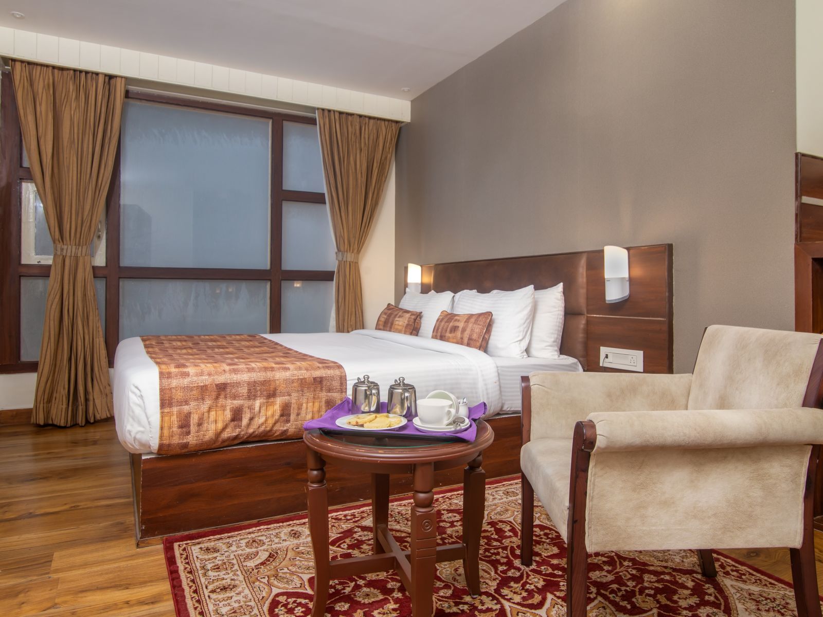 An image of a room with a queen size bed, TV and a chair and a table - Sumitel Vista TV Tower