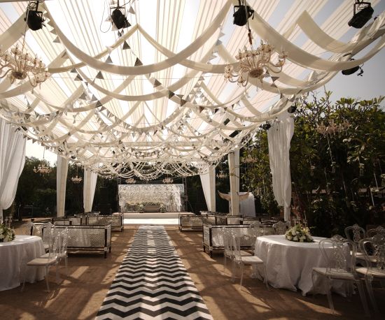 alt-text a decorated walkway to the stage with seating arrangements on the side - heritage village resorts & spa, Manesar