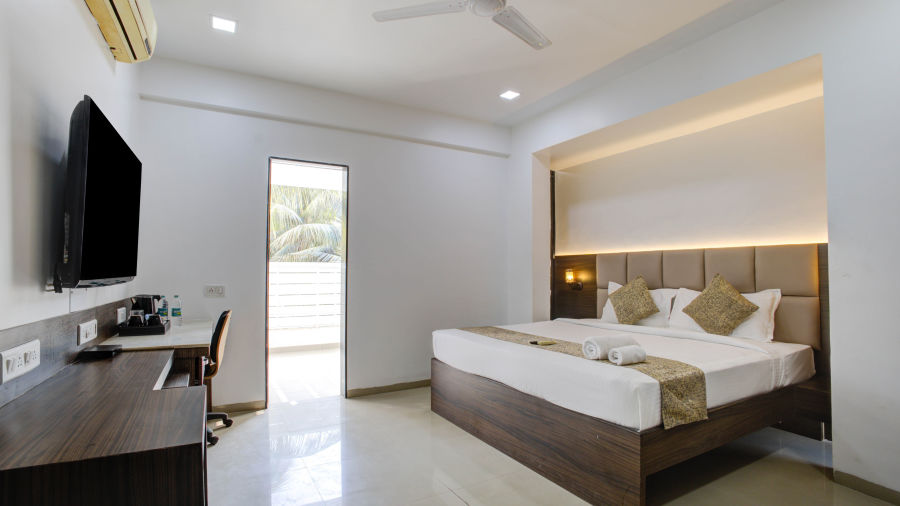 A double bed with side tables and lamps inside one of the rooms - Aerith Studio, Kharadi