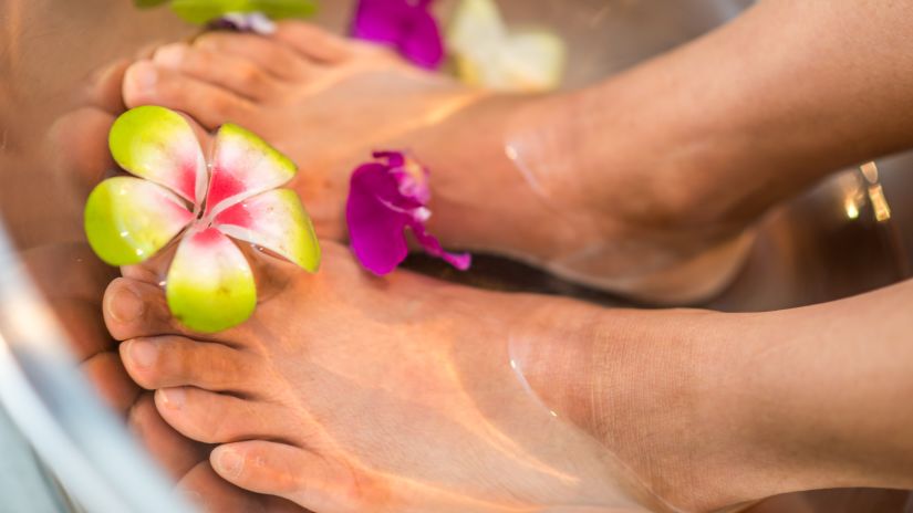 Image of feet dipped in a basin of water with a flower