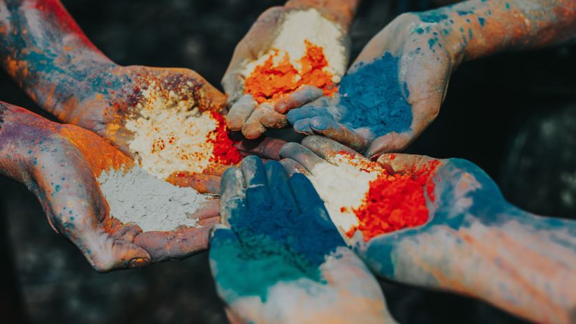 people holding colour powders in their hands