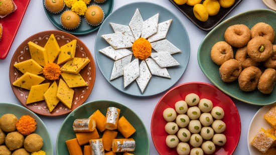 Assorted Indian sweets on a table in different plates