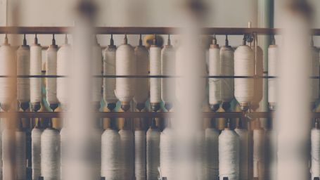 a close up shot of threads being woven into usable threads