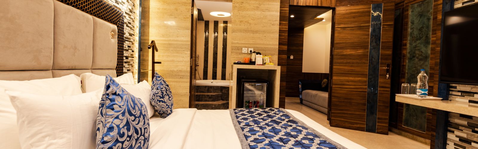 a view of a bed decked with royal blue pillows and blanket at Queen suite in Hotel Park Elanza, Coimbatore