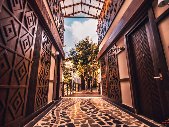 Tiled pathway with wooden decor on either side leading outside - Symphony Samudra Beachside Jungle Resort And Spa, Port Blair