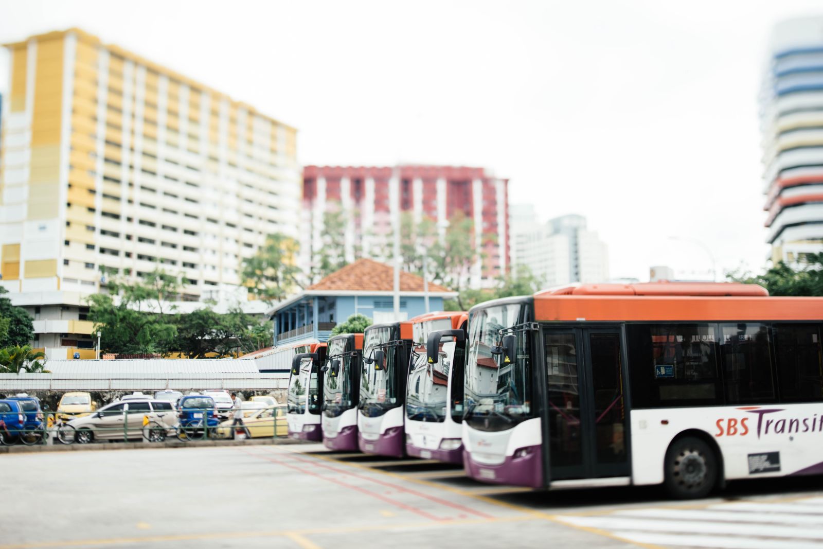 Busses parked in the bus depot with building in the background