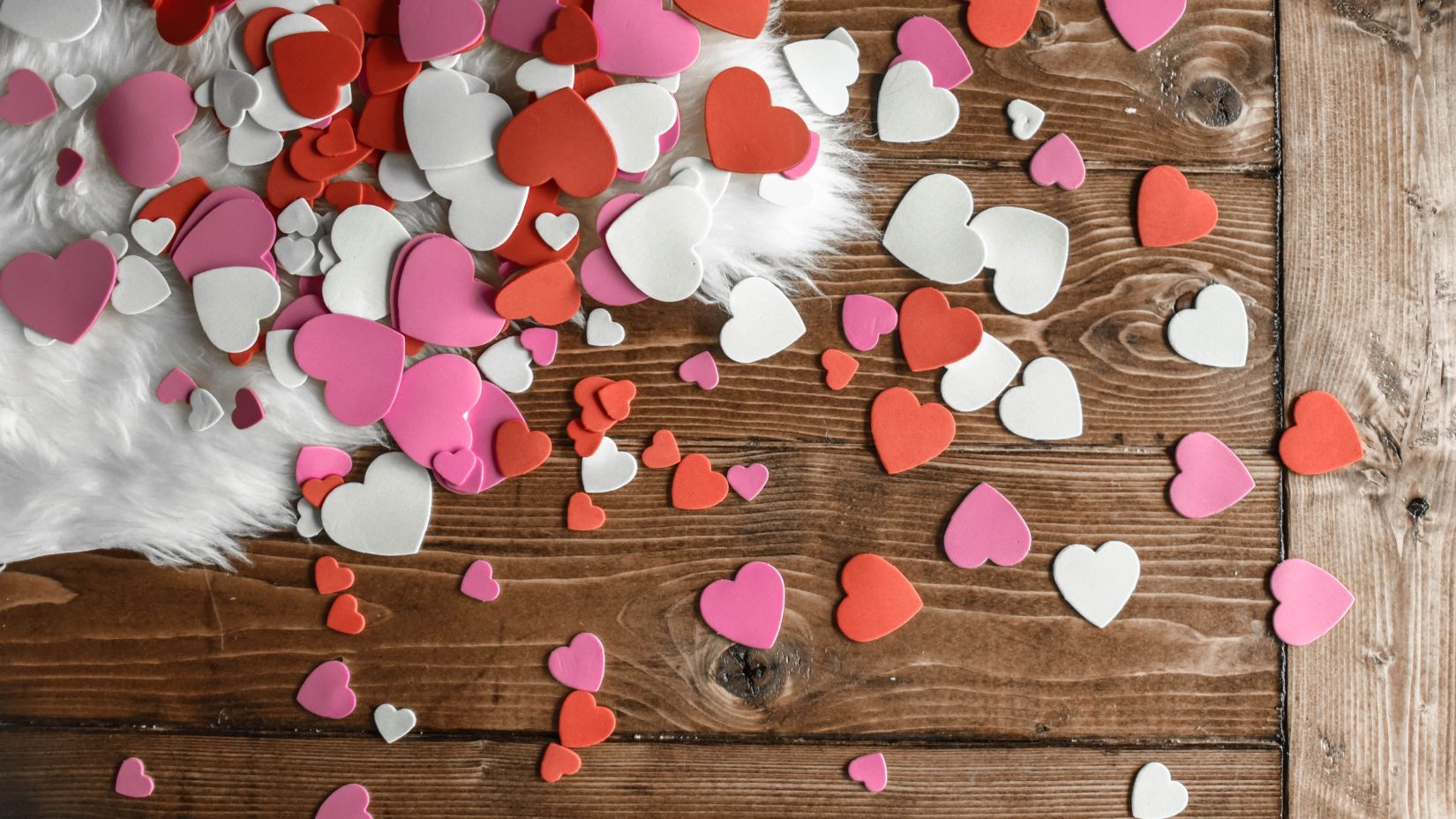 a desk with heart -shaped cut out papers scattered on top 