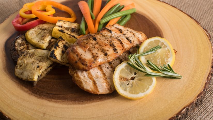 a plate of steak with lemon slices and veggies