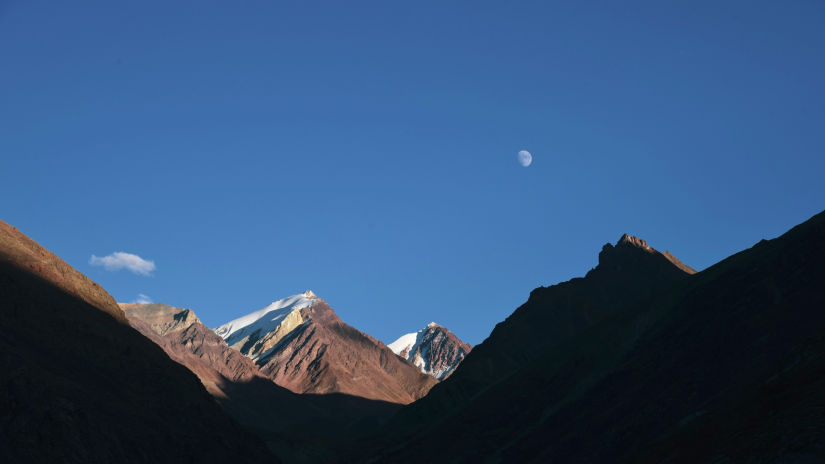 Snowcapped mountains with mood glowing on top