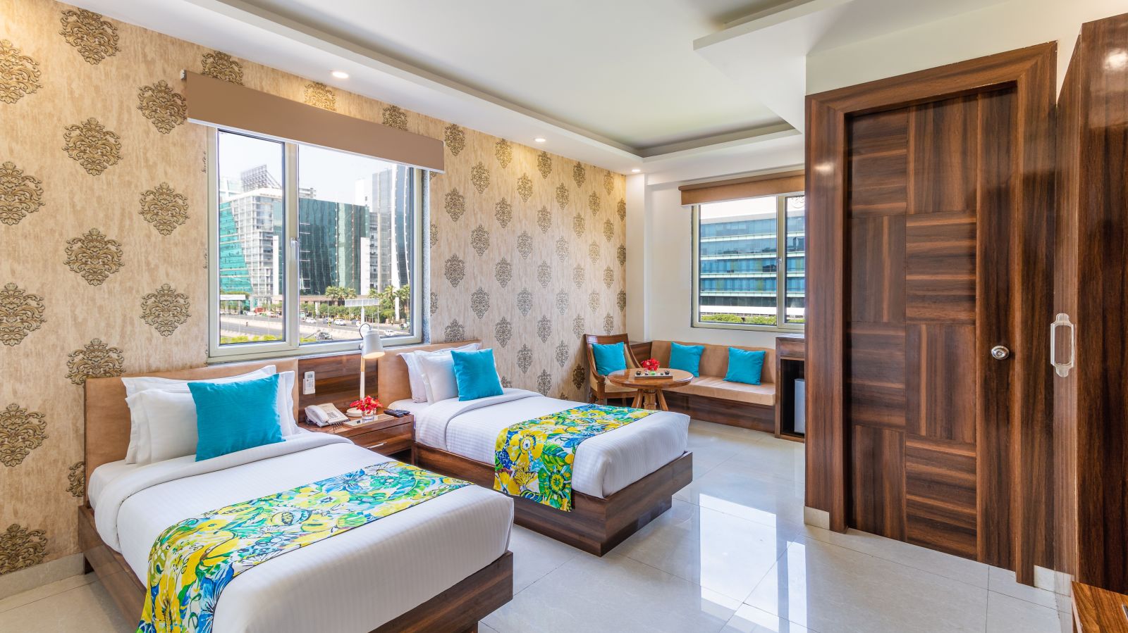 side view image of Super Deluxe Twin Room featuring twin beds, sofa, window and a TV | Inde Hotel Cyber City