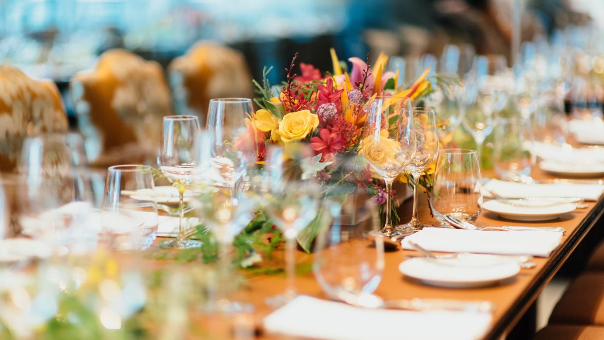 a long table decked with flowers and plates