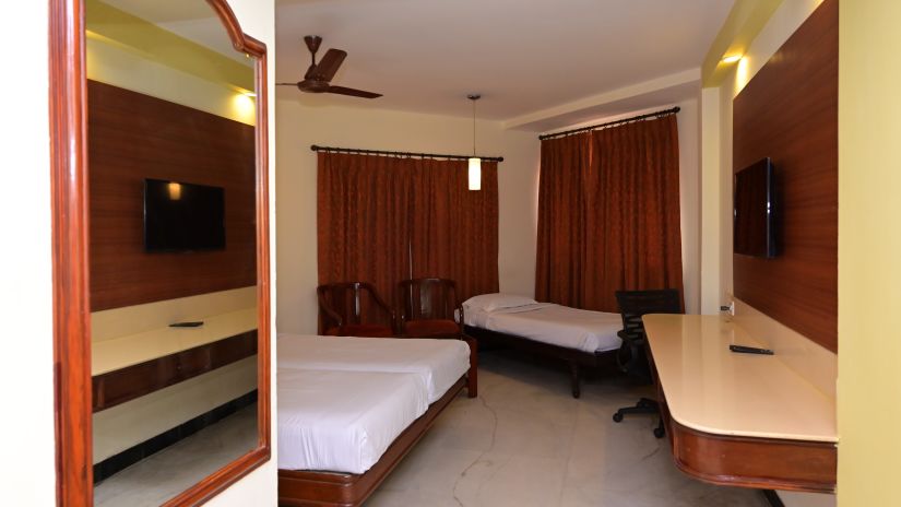 View of Standard Room for triple occupancy with partial view of plush bed and basic amenities - Jayaram Hotel, Pondicherry