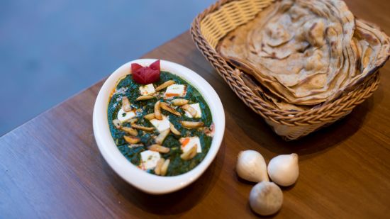 a palak dish with rotis on side in a basket - VITS Sharanam, Thane