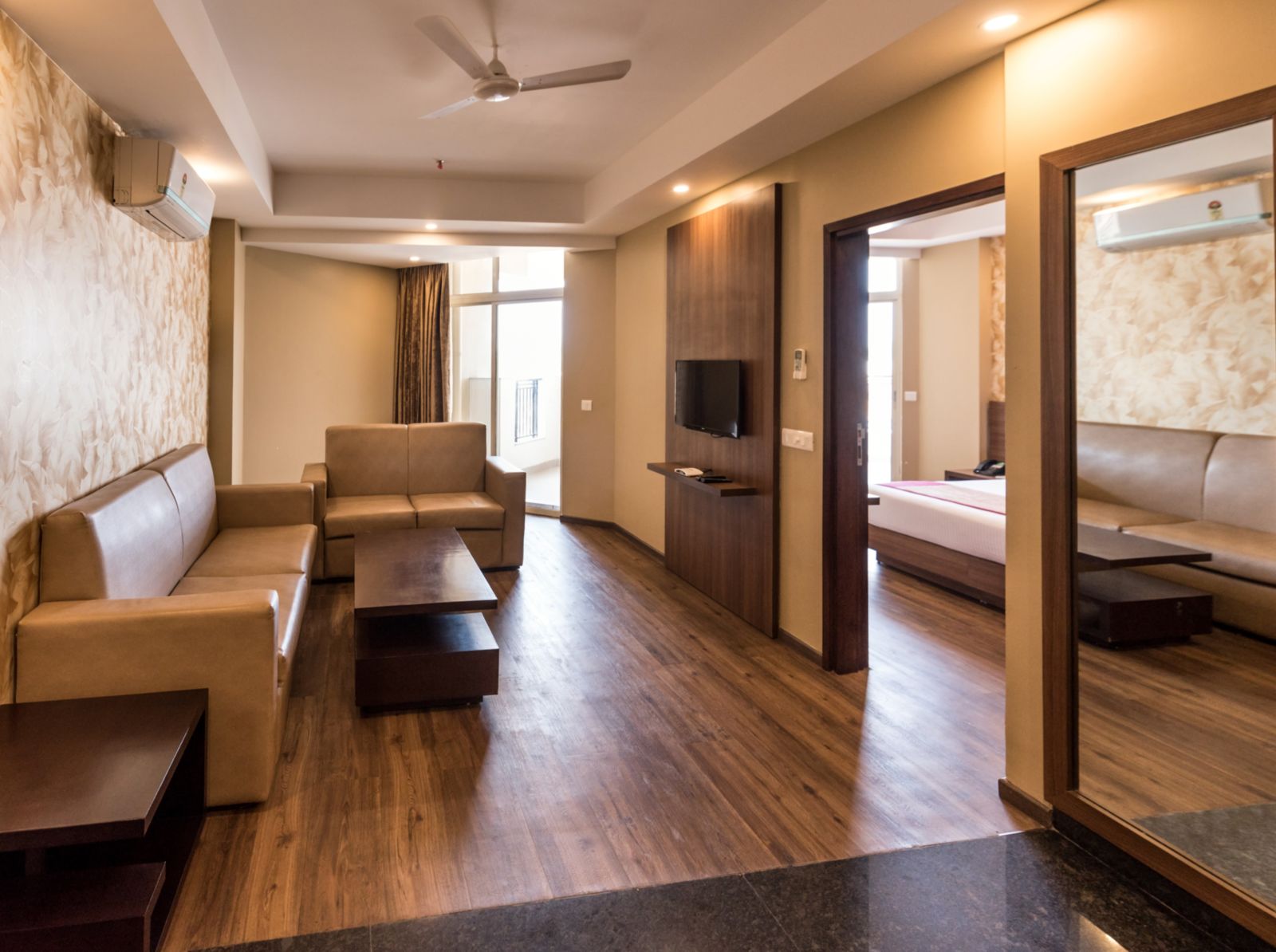 Suites Room with Complimentary Wi-Fi in a hotel room with separate living room that features a couch and a separate bedroom with a queen size bed - Le ROI Digha Hotel West Bengal8