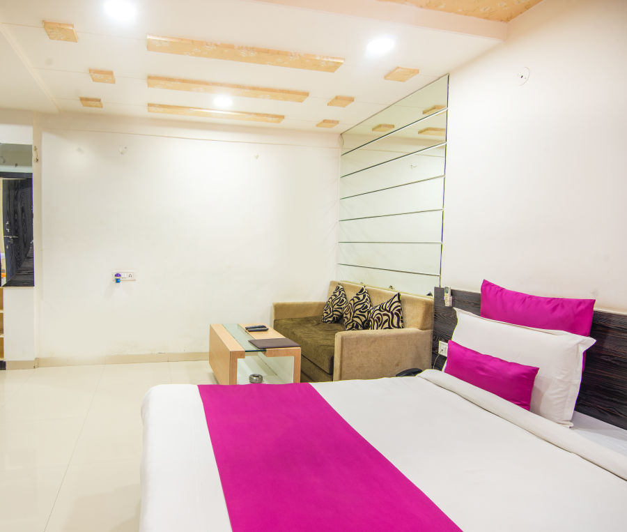 alt-text A room featuring a bed, a TV, a coffee table, and a sofa bed - Morya Regency, Bhopal