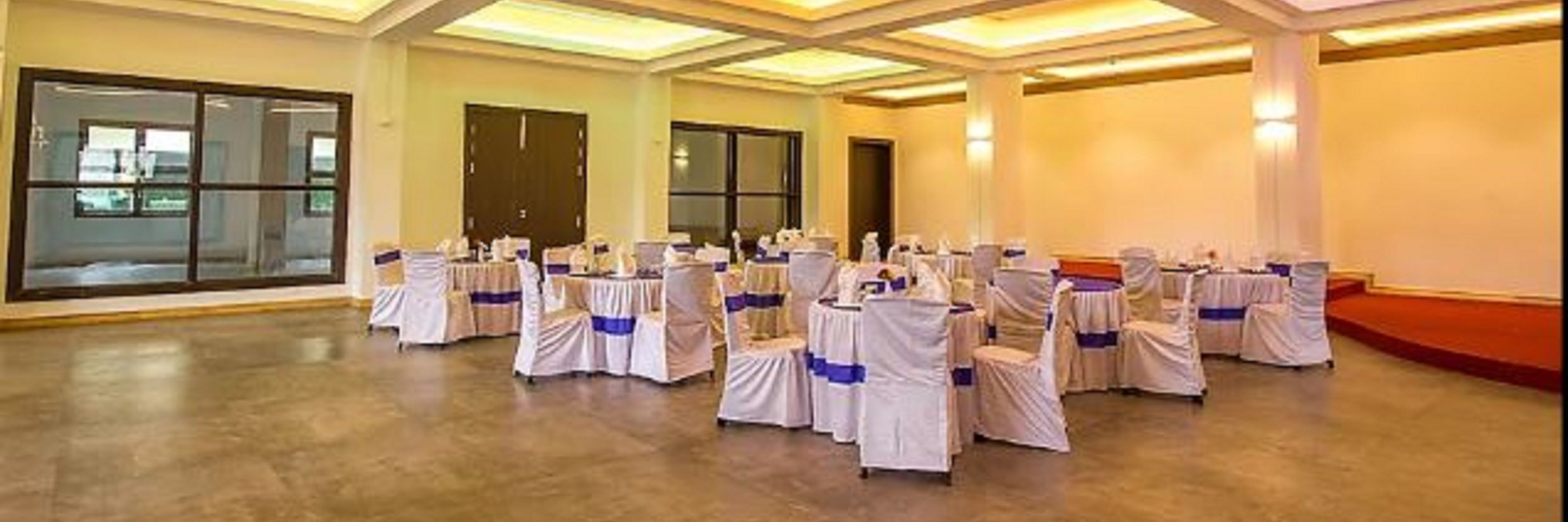 A wide view of chairs and tables in a closed hall with windows | Meeting Halls in Sanderling